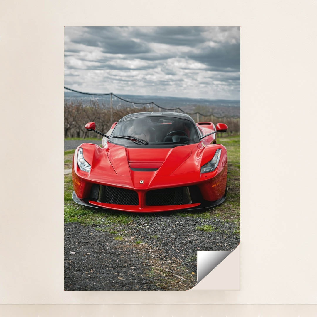 This photo shows a red Ferrari LaFerrari viewed from the front, parked outdoors under a cloudy sky, unframed style.