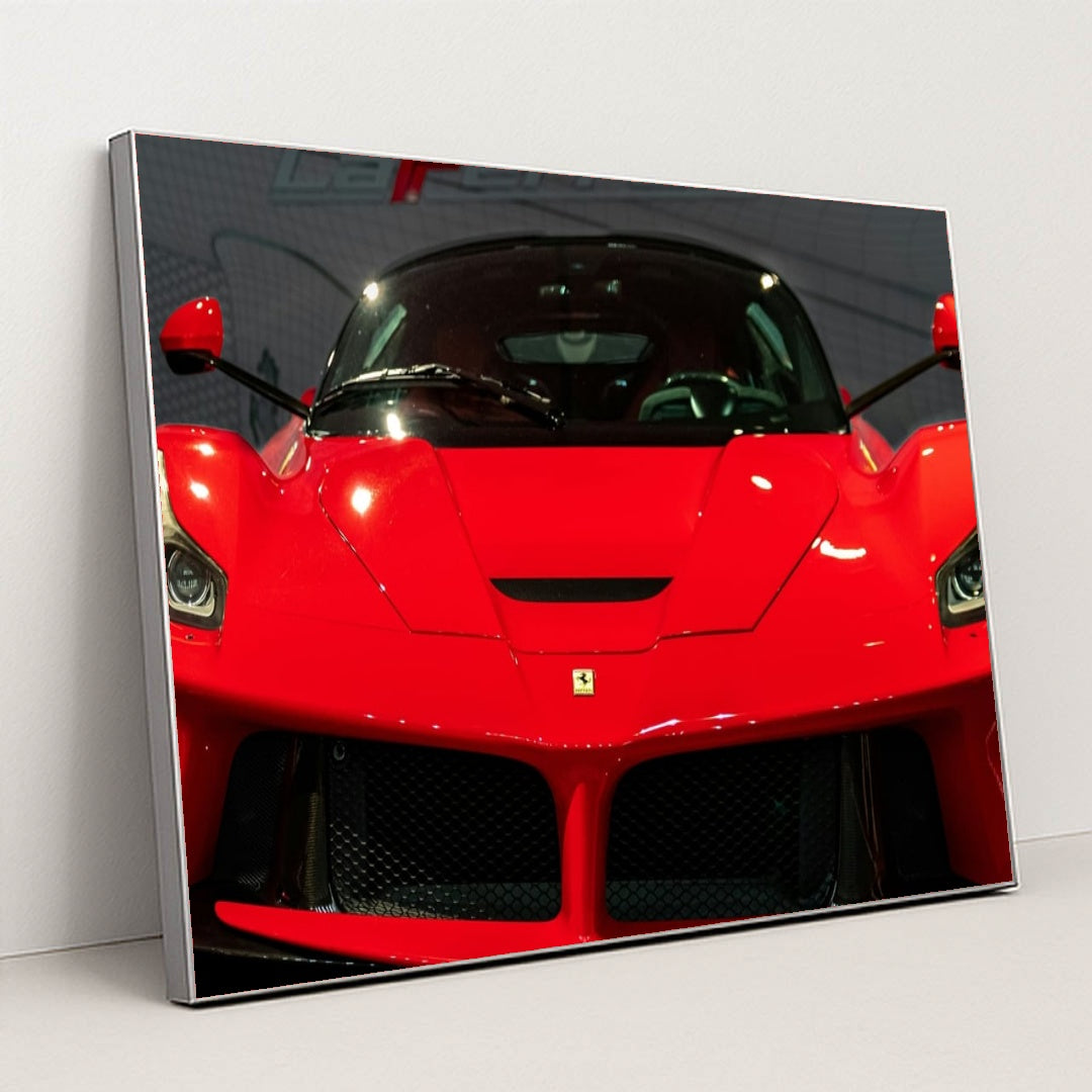 This photo shows the front view of a red Ferrari LaFerrari at an indoor car show, in a silver frame.