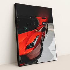 This photo shows a close-up of a red Ferrari LaFerrari highlighting its sleek curves and headlight, in a black frame.