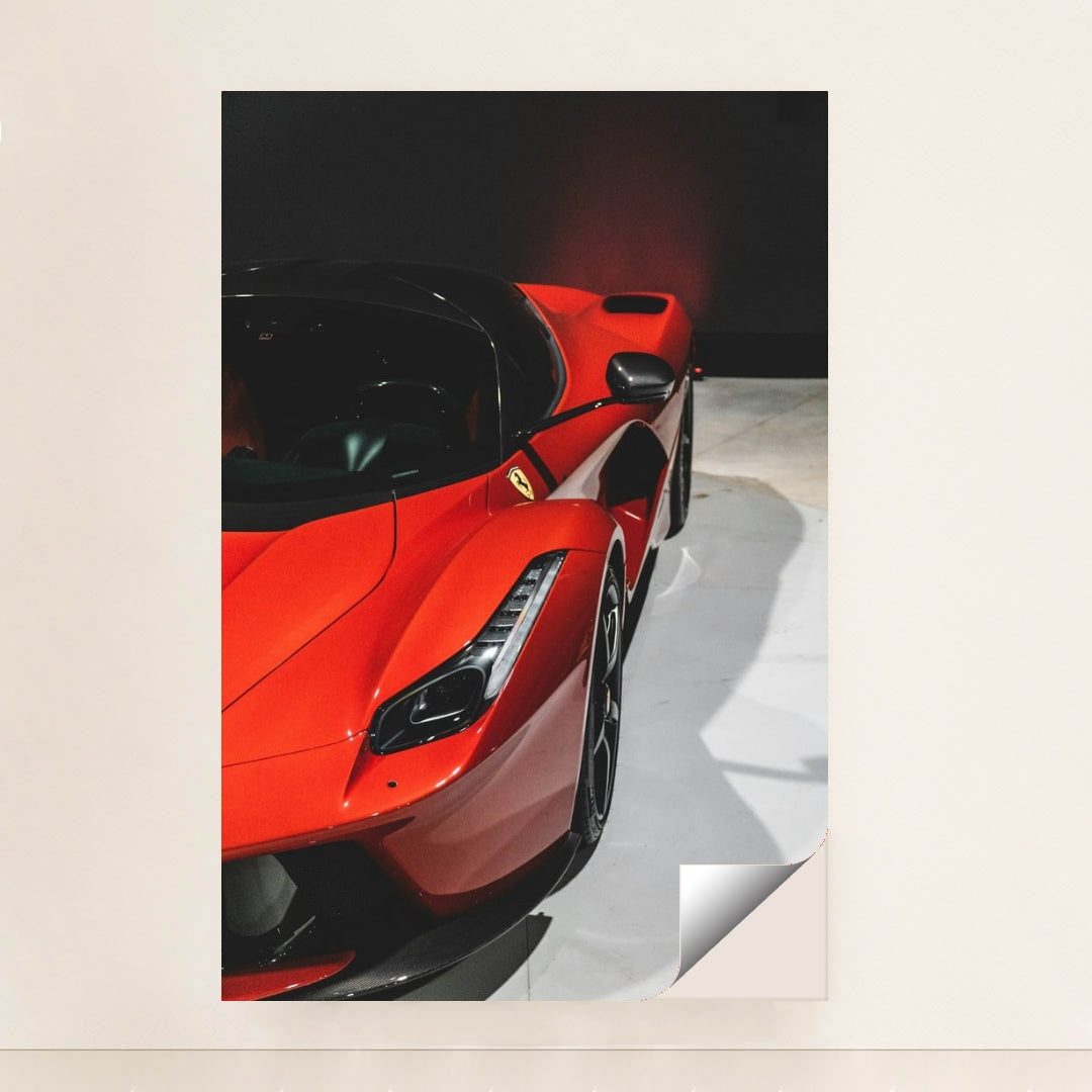 This photo shows a close-up of a red Ferrari LaFerrari highlighting its sleek curves and headlight, minimalist unframed style.