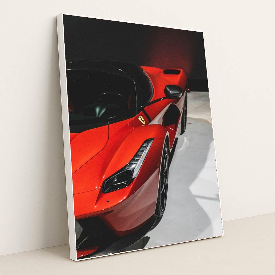 This photo shows a close-up of a red Ferrari LaFerrari highlighting its sleek curves and headlight, in a white frame.