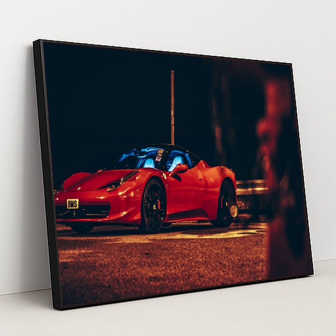 This photo shows a red Ferrari sports car parked at night under orange streetlights, with a blue-lit interior, in a black frame.