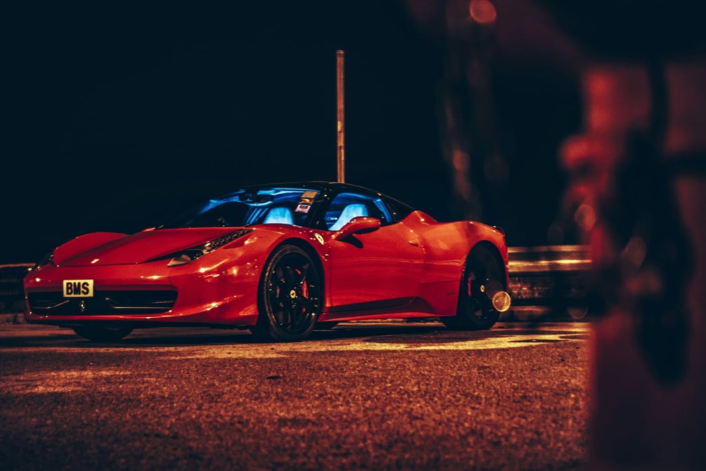 Ferrari 458 Italia at Night parked on a dark street with streetlights, showcasing its sleek design and black alloy wheels.