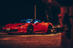 Ferrari 458 Italia at Night parked on a dark street with streetlights, showcasing its sleek design and black alloy wheels.