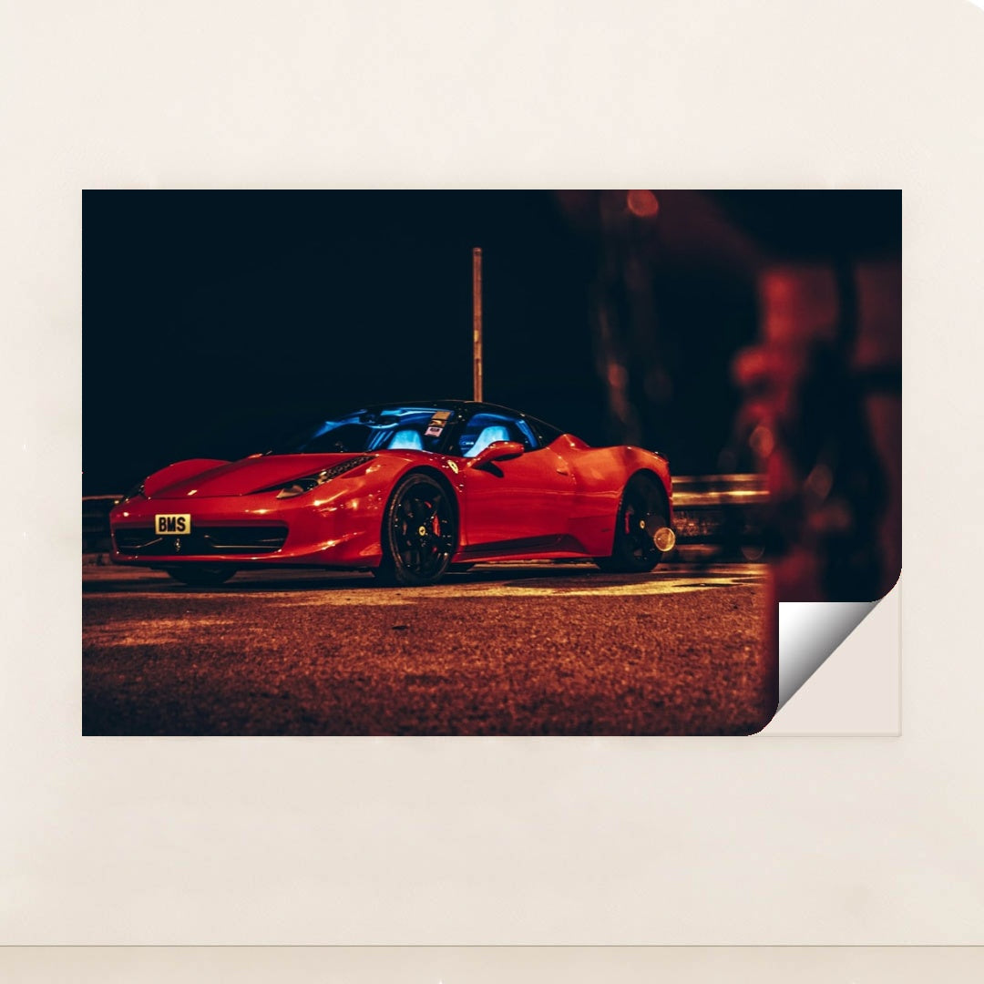 This photo shows a red Ferrari sports car parked at night under orange streetlights, with a blue-lit interior, minimalist unframed style.