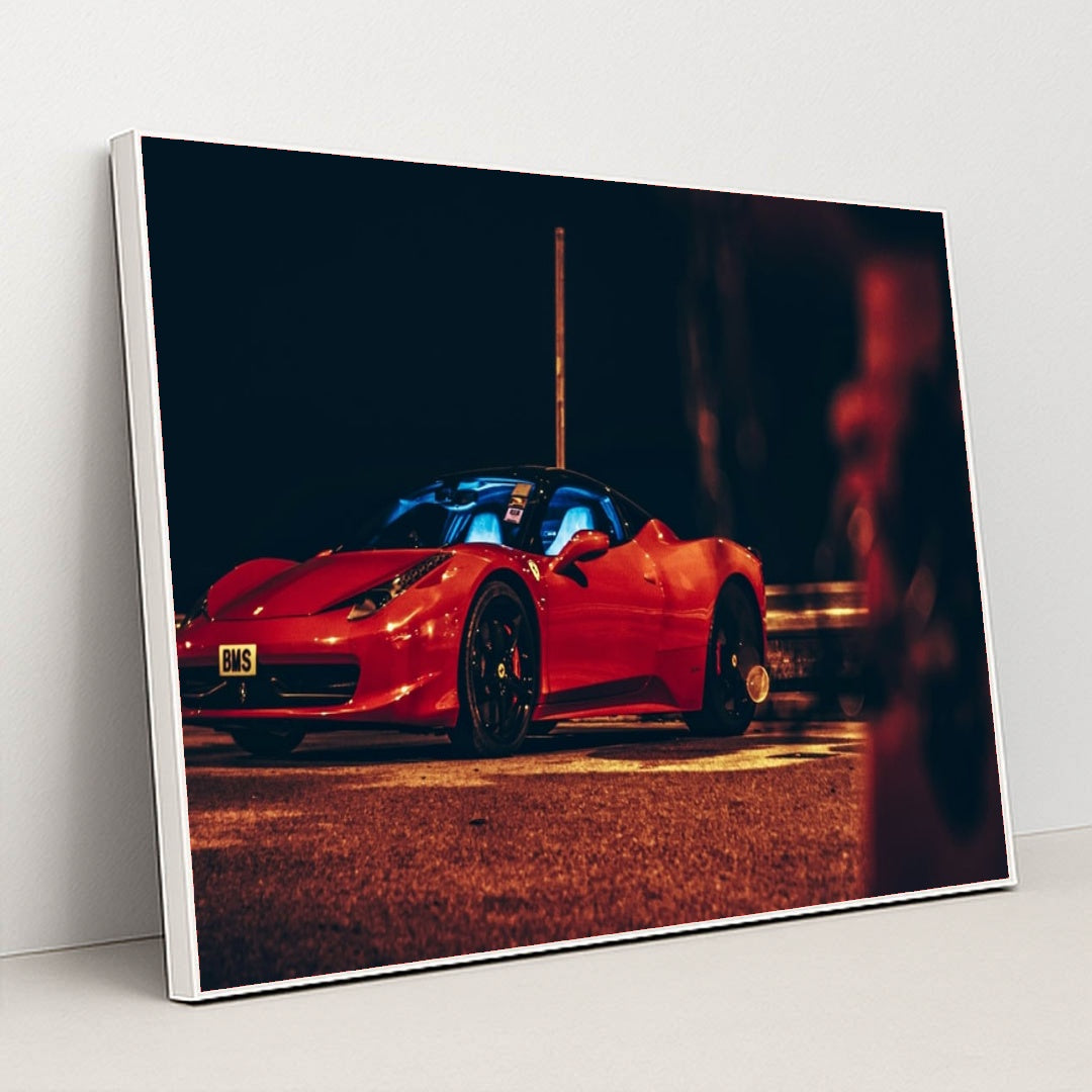 This photo shows a red Ferrari sports car parked at night under orange streetlights, with a blue-lit interior, in a white frame.