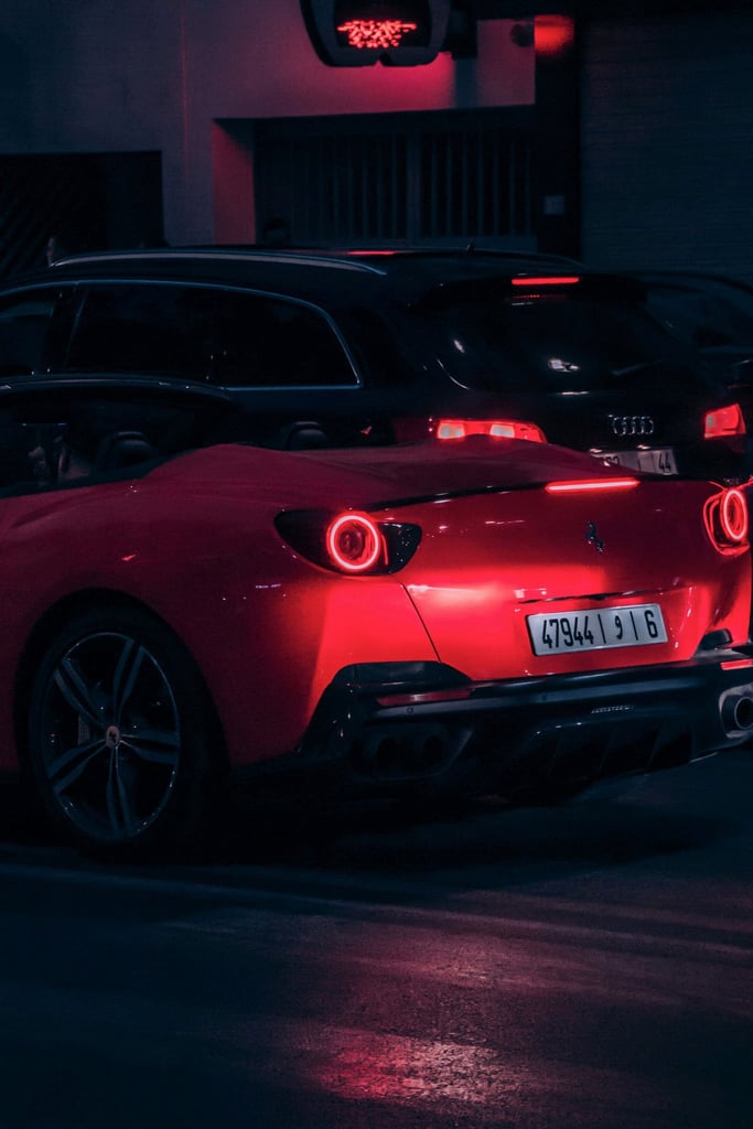 Ferrari Portofino at Night showcasing its vibrant Rosso Corsa paint and hypnotic taillights in a cinematic urban setting.
