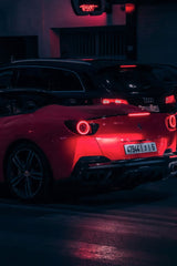 Ferrari Portofino at Night showcasing its vibrant Rosso Corsa paint and hypnotic taillights in a cinematic urban setting.