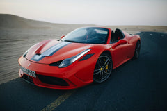 Ferrari 458 Speciale Aperta in the Dunes with striking Rosso Corsa red body and bold racing stripe on a desert road.