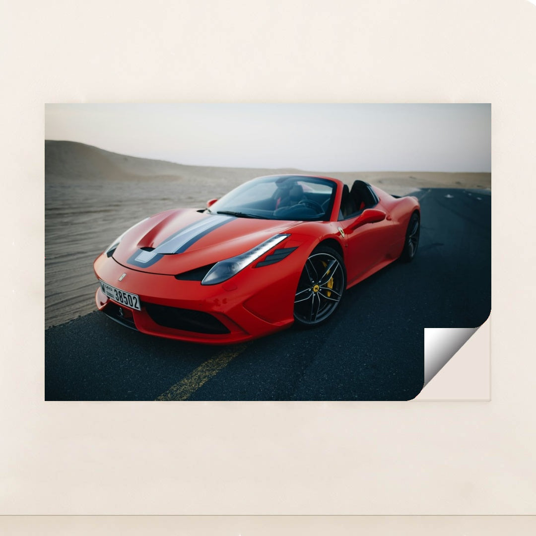 This photo shows a red Ferrari convertible with a blue-and-white racing stripe parked on an empty desert road at dusk, minimalist unframed style.