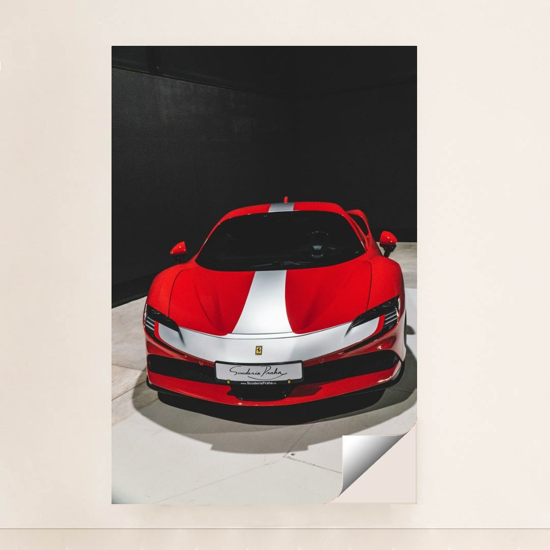 This photo shows a red Ferrari sports car with a white racing stripe parked indoors under direct lighting, minimalist unframed style.