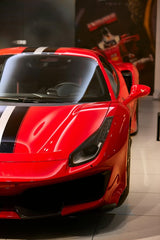Ferrari 488 Pista in Focus: close-up of red sports car with racing stripes in modern showroom setting, car wall art.