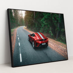 This photo shows a red Ferrari sports car with white stripes parked on a winding forest road, in a black frame.