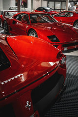 A Ferrari Collection showcasing iconic red Ferrari models, including the F40 and Enzo, framed by dramatic lighting.
