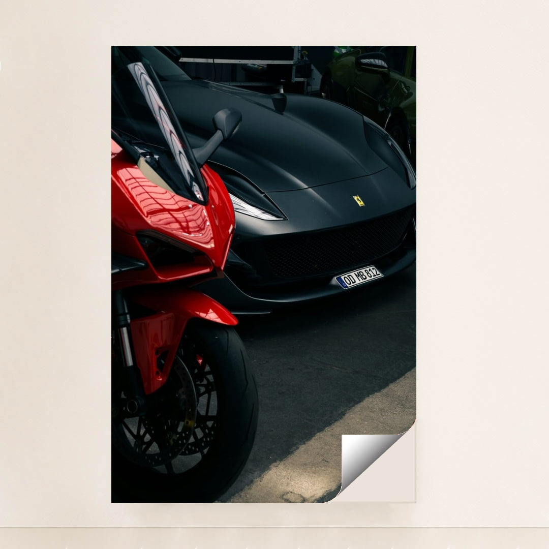 This photo shows a red sport motorcycle next to a matte black Ferrari sports car in a parking area, minimalist unframed style.
