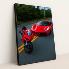 This photo shows a red Ducati motorcycle and a red Ferrari sports car parked side by side on a rural road, in a black frame.