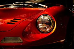 Close-up of Ferrari Dino 246 GT Timeless Design car wall art showcasing its iconic fender and glass headlight.
