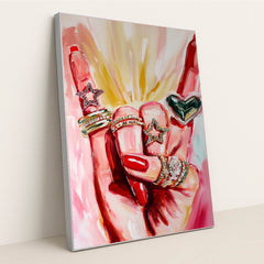 This artwork shows a hand with red nails wearing sparkly rings shaped like stars and a heart, set against pink painted brushstrokes, in a silver frame.