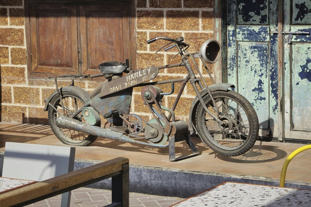 aboodi vesakaran - Rusty antique Harley Davidson motorcycle displayed outdoors in Dubai.