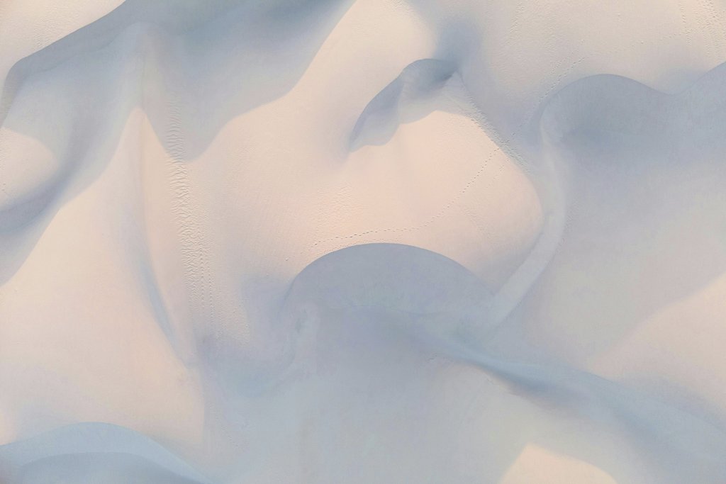 Jeremy Bishop - Aerial abstract view of serene desert dunes with soft pastel hues.