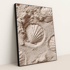 This artwork features white scallop shell imprints in smooth pale sand, in a black frame.