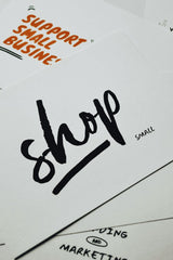 Eva Bronzini - A close-up of a card with 'shop small' message promoting local small businesses.