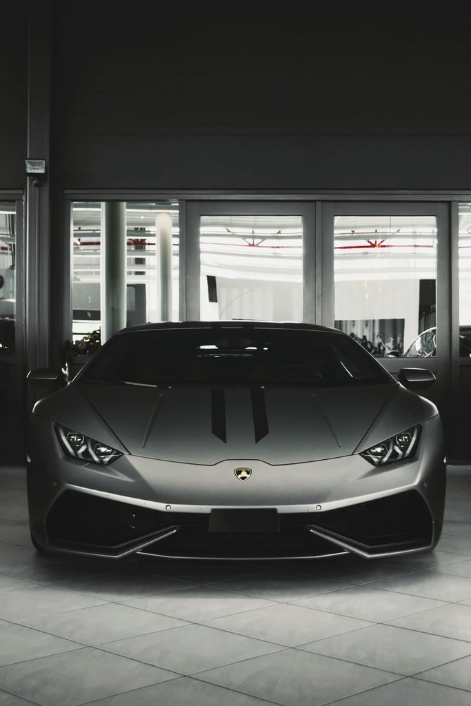 Lamborghini Stare Down - Matte gray Lamborghini supercar showcased in a modern showroom, exemplifying car wall art.