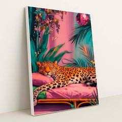 This artwork shows a lounging leopard on a pink couch surrounded by tropical plants and a sparkling disco ball, in a white frame.