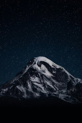 Maksim Samuilionak - A snow covered mountain under a night sky filled with stars photo