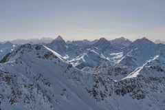 Susanne Jutzeler, suju-foto - Stunning panoramic view of snow-covered mountain range under a clear blue sky, capturing the beauty of winter.