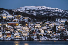 Pixabay - Charming snowy village set against Norwegian winter landscape illuminated at twilight.