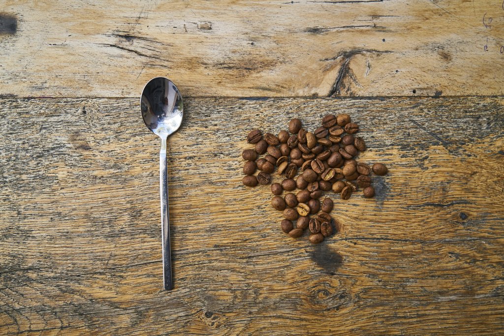 Engin Akyurt - A flat lay of roasted coffee beans and a spoon on a rustic wooden table, showcasing coffee's aromatic appeal.