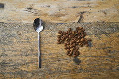 Engin Akyurt - A flat lay of roasted coffee beans and a spoon on a rustic wooden table, showcasing coffee's aromatic appeal.