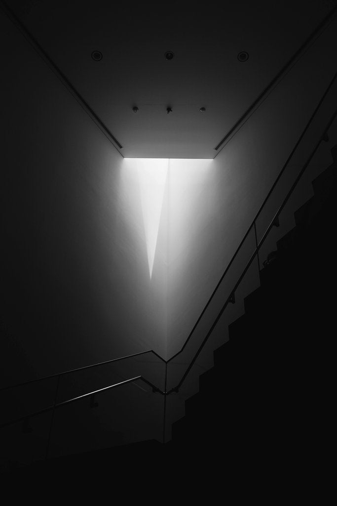 IAN - A striking minimalist black and white photograph of a modern staircase with geometric lighting.