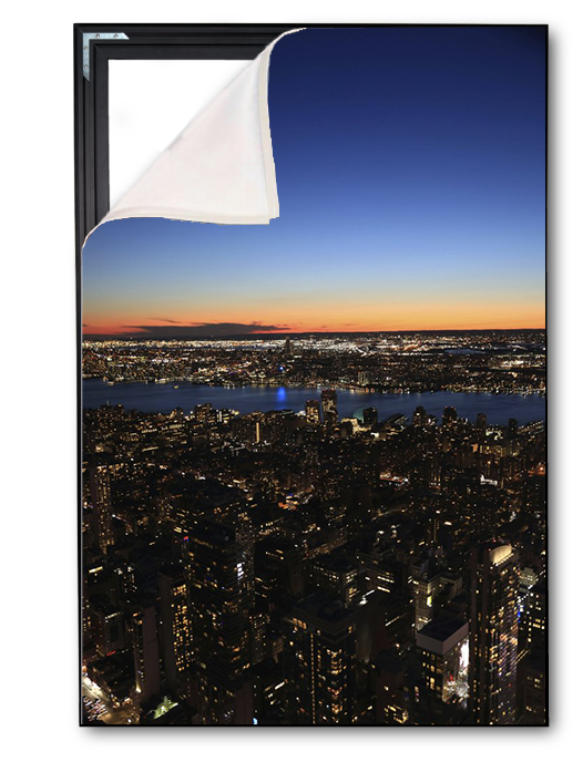 Cityscape at night with a large frame showing a sunset over water.