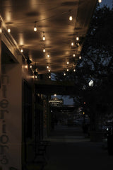 Connor McManus - Charming evening street with warm lights creating a cozy atmosphere.