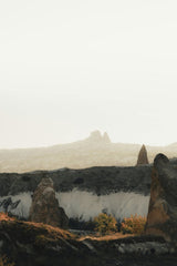 Emir Anık - A captivating view of rugged rock formations under a misty sky, evoking a sense of mystery.