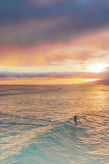 Jess Loiterton - A lone surfer embraces the setting sun with vibrant skies on the ocean. Perfect for themes of adventure and nature.