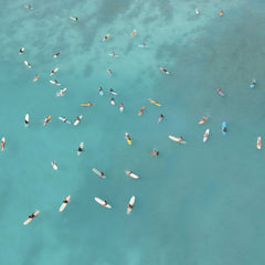 Jess Loiterton - Aerial shot of surfers in vibrant turquoise water, capturing a serene beach scene.