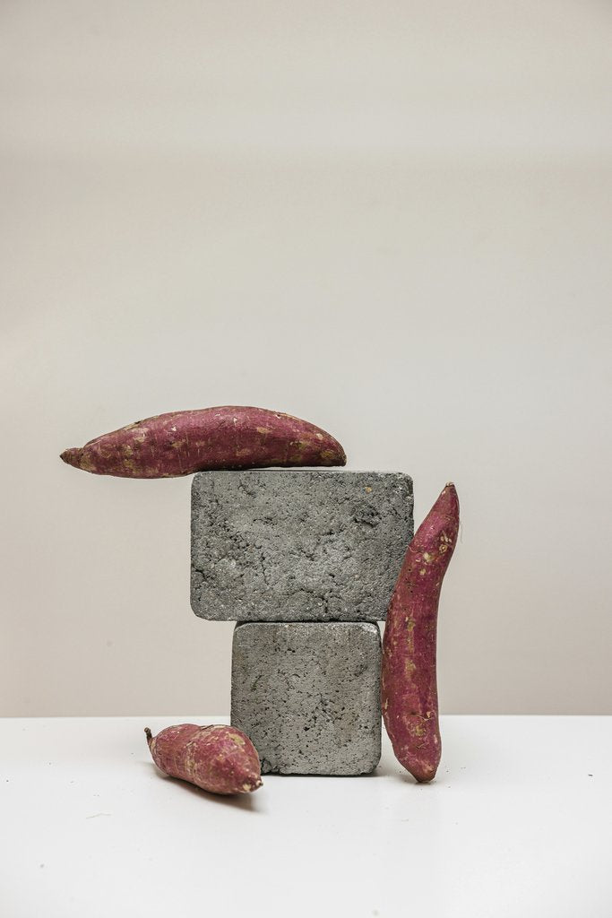 Cup of  Couple - A creative still life featuring sweet potatoes artfully arranged on gray concrete blocks, showcasing texture contrast.