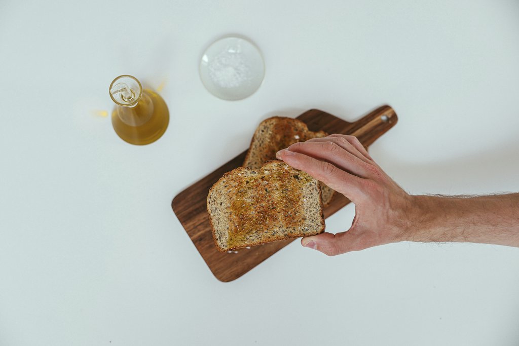 Cup of  Couple - A minimalist breakfast setup with toasted whole grain bread, olive oil, and salt on a wooden board.