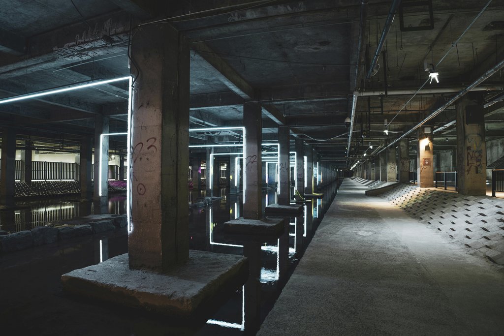 KOREAN JH - Explore the eerie ambiance of an abandoned industrial structure illuminated by neon lights and water reflections.