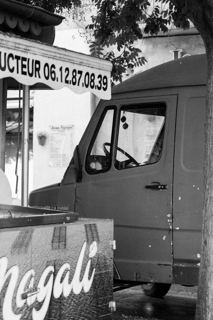 Arthur  Swiffen - Black and white photo of an urban street scene featuring a van next to a stall.