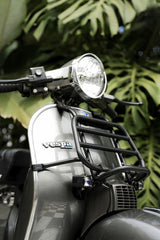 Labskiii - Vintage Vespa scooter front view with lush green tropical leaves background.