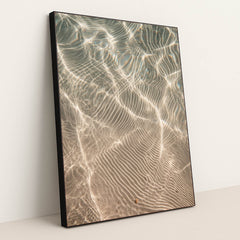 This artwork features shimmering sunlight patterns rippling across sandy underwater textures, displayed in a black frame.