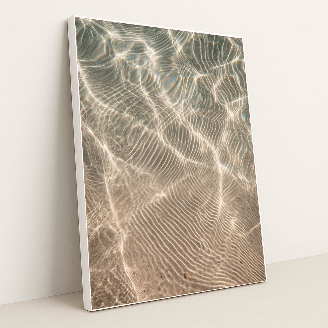 This artwork features shimmering sunlight patterns rippling across sandy underwater textures, displayed in a white frame.