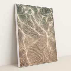 This artwork features shimmering sunlight patterns rippling across sandy underwater textures, displayed in a white frame.