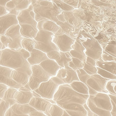 This artwork features sunlight reflecting on shallow sand and water, creating bright abstract patterns.