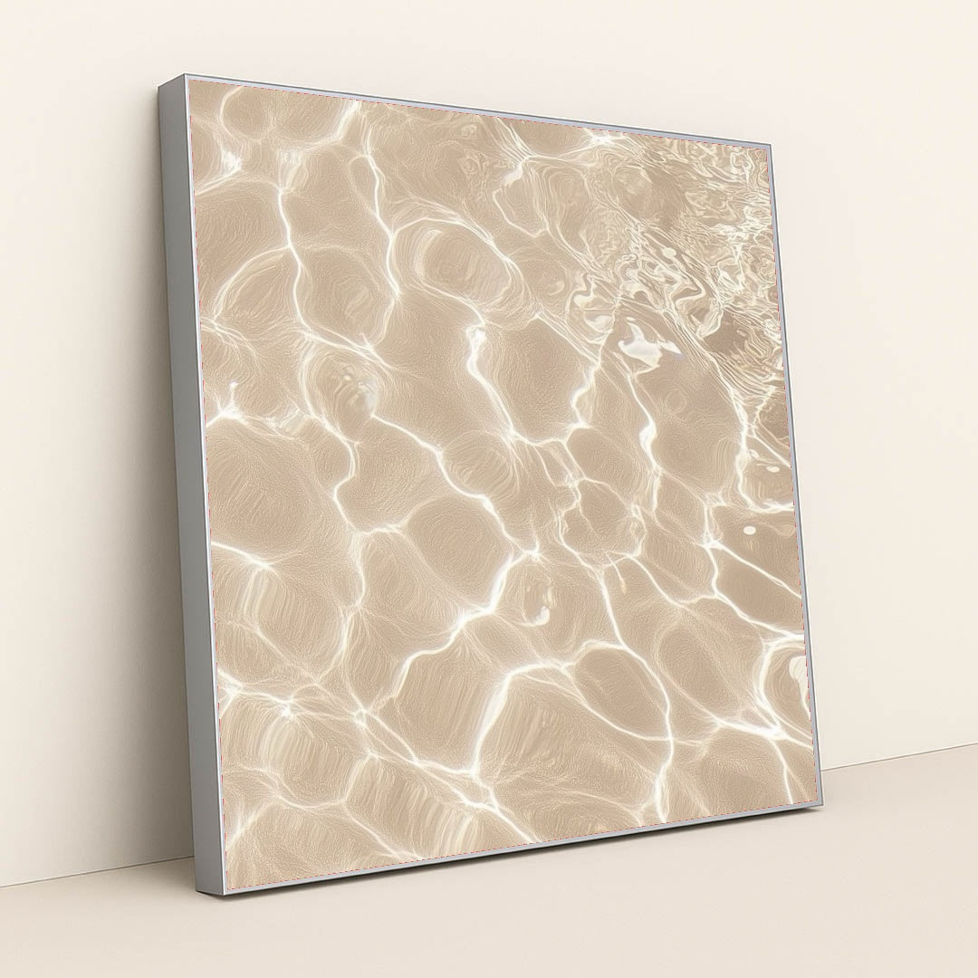 This artwork features sunlight reflecting on shallow sand and water, creating bright abstract patterns, in a silver frame.