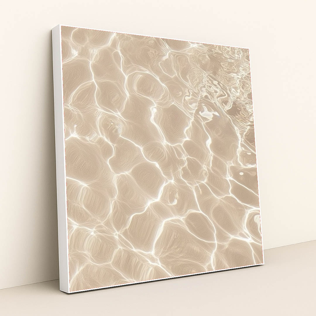 This artwork features sunlight reflecting on shallow sand and water, creating bright abstract patterns, in a white frame.